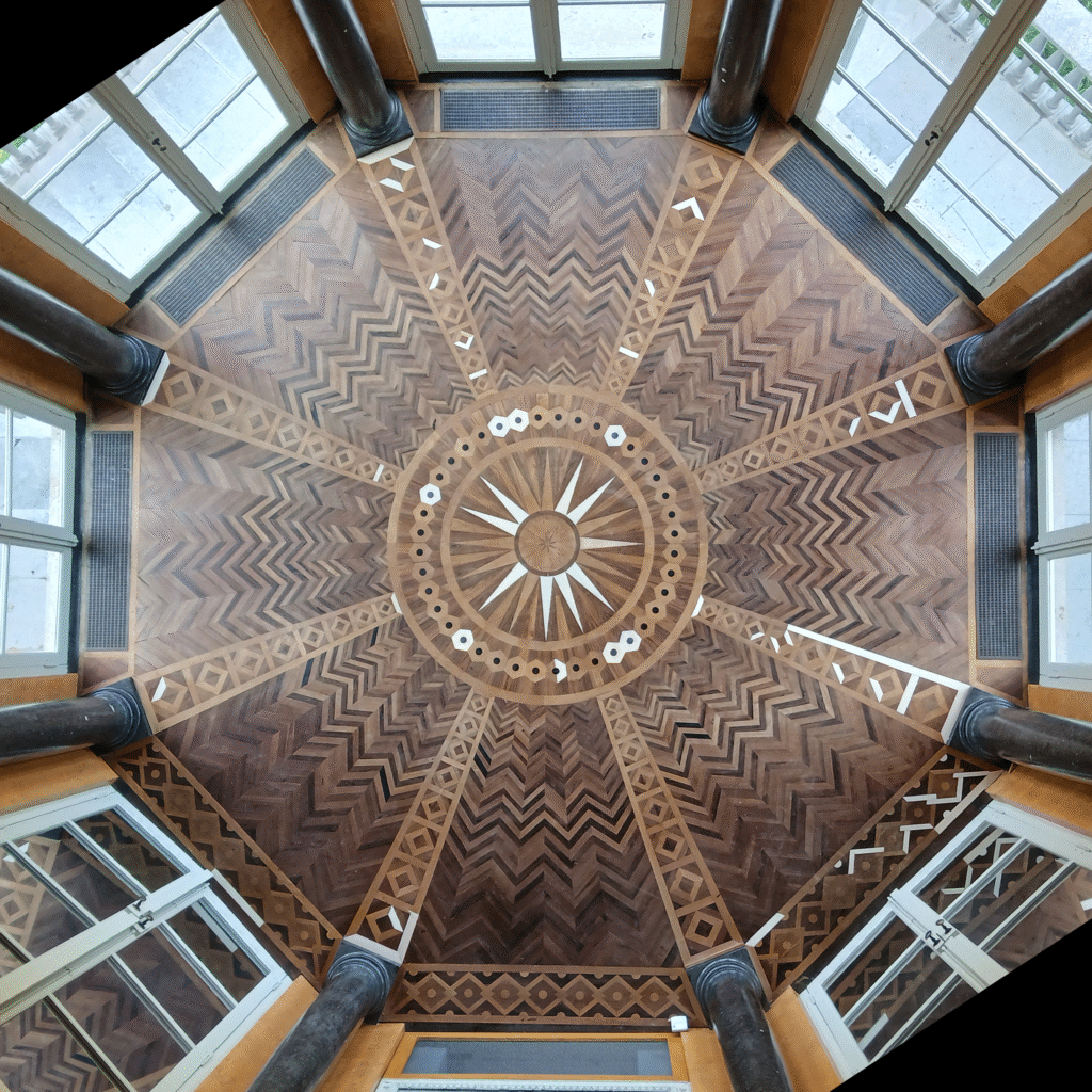 De parketvloer tijdens restauratie, met duidelijk zicht op de nieuwe inzetstukken.